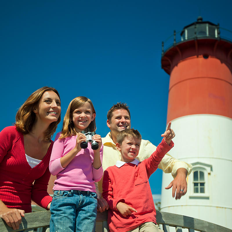 Family taking pictures outside of lighthouse