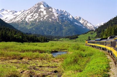 alaska denali national park train moving snow capped mountains