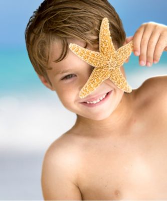 Boy holding up star fish to his face
