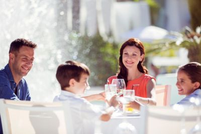 couple family with children raising toast at table outdoors