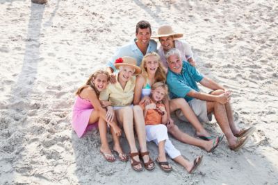 family on beach taking three generation photo