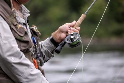 fisherman fly fishing in river