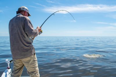 fisherman sets hook on large fish