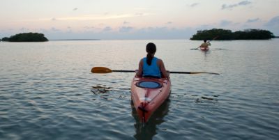 Couple kayaking while watching sunset
