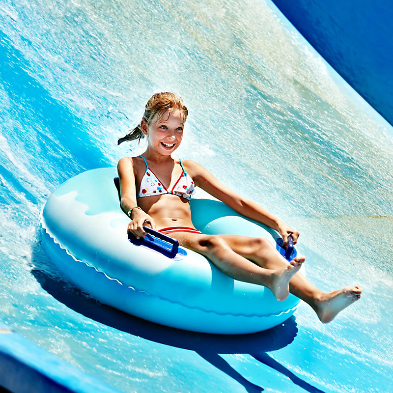 Girl water tubing down water slide