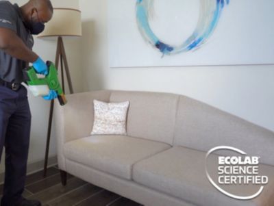 Man cleaning couch with special equipment