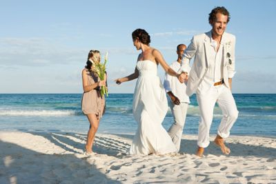 married couple on beach with friends ocean