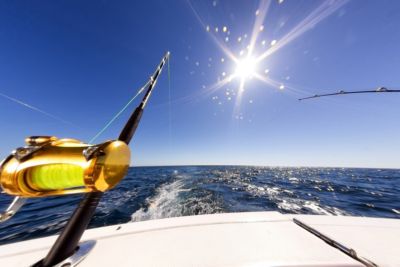 two deep sea fishing rods on boat in ocean