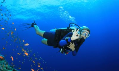 Woman exploring coral reef during scuba diving  